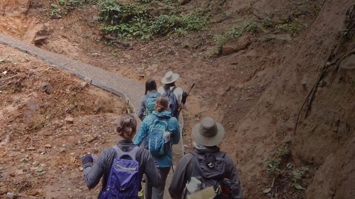 Students 和 faculty hiking across a terrain on a 出国留学 trip