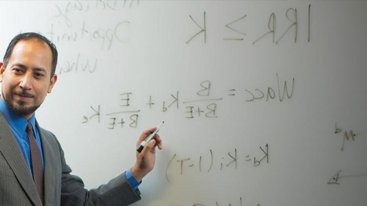 教授 teaching at a whiteboard facing a class