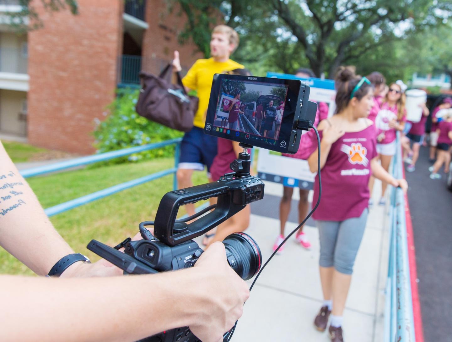 a video camera is in focus filming the action in the first-year quad during Move-In Day