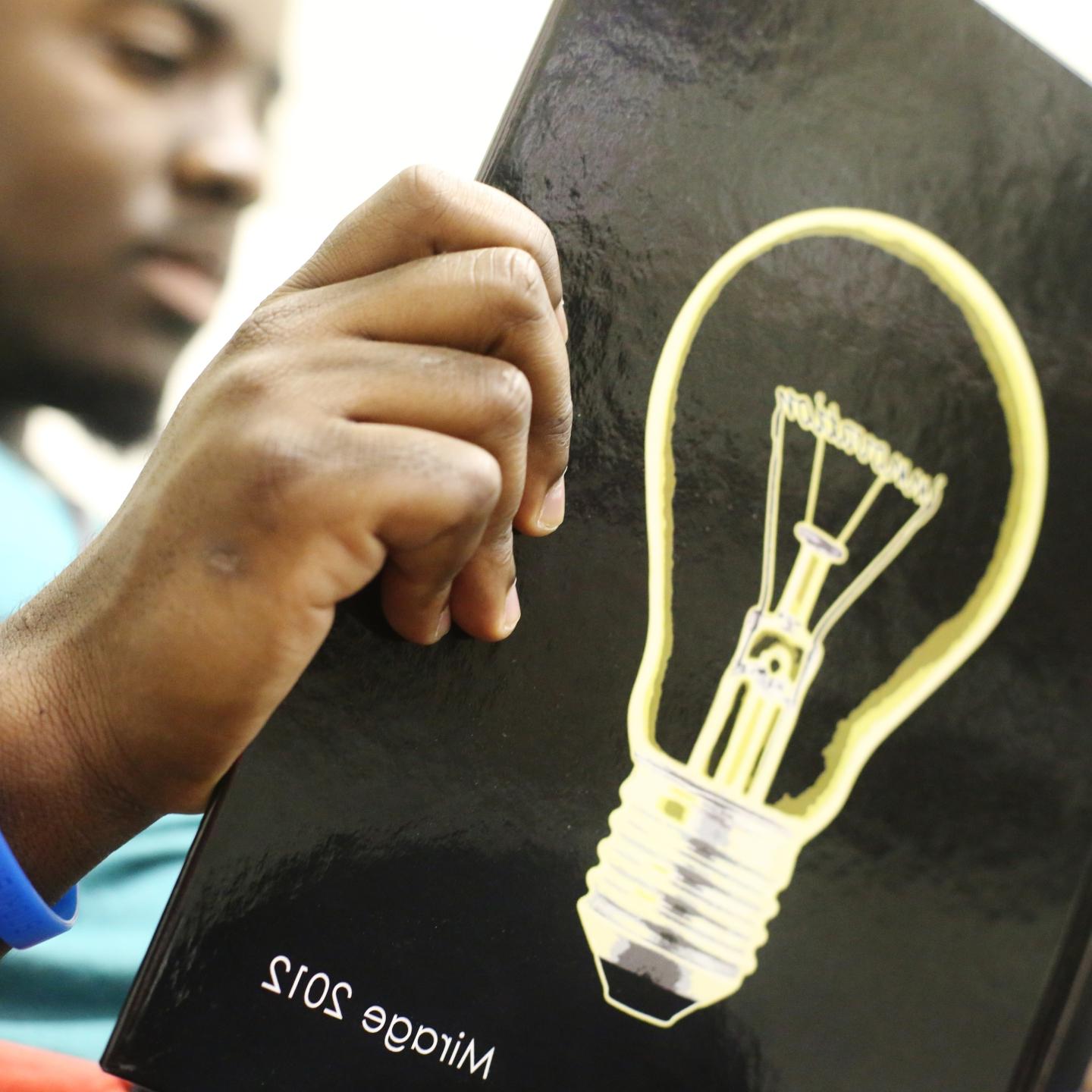 a student reads the 2012 海市蜃楼 with a lightbulb on the cover