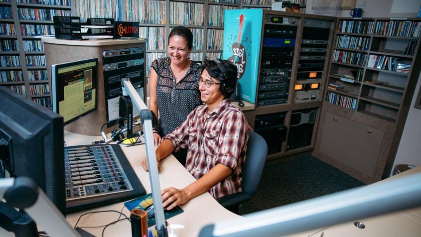 a student and staff member work on-air in the KRTU studio