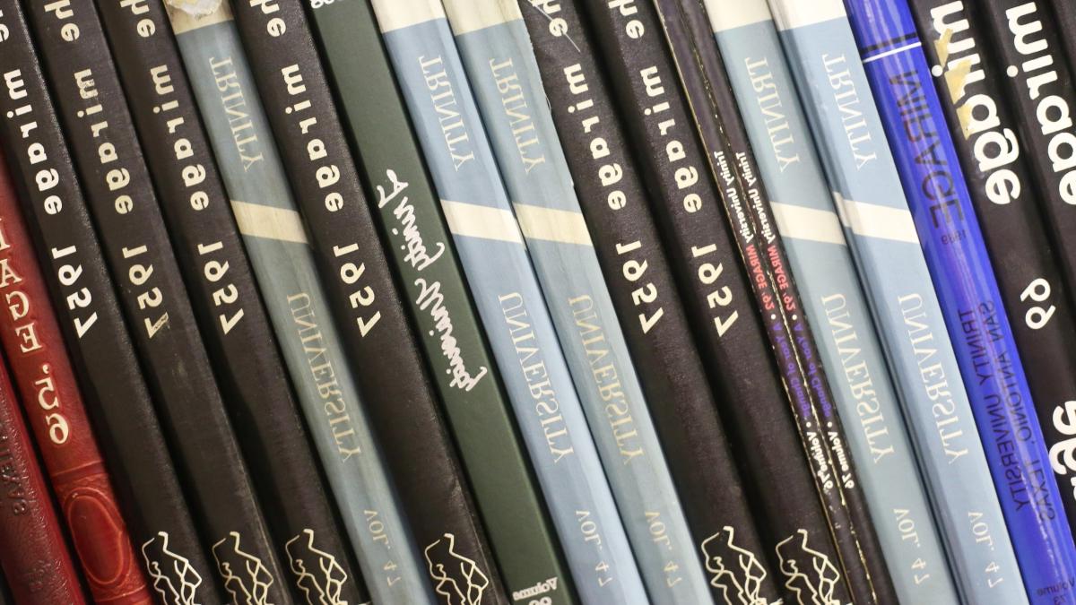 more than 20 Mirage yearbook spines are stacked on a bookshelf